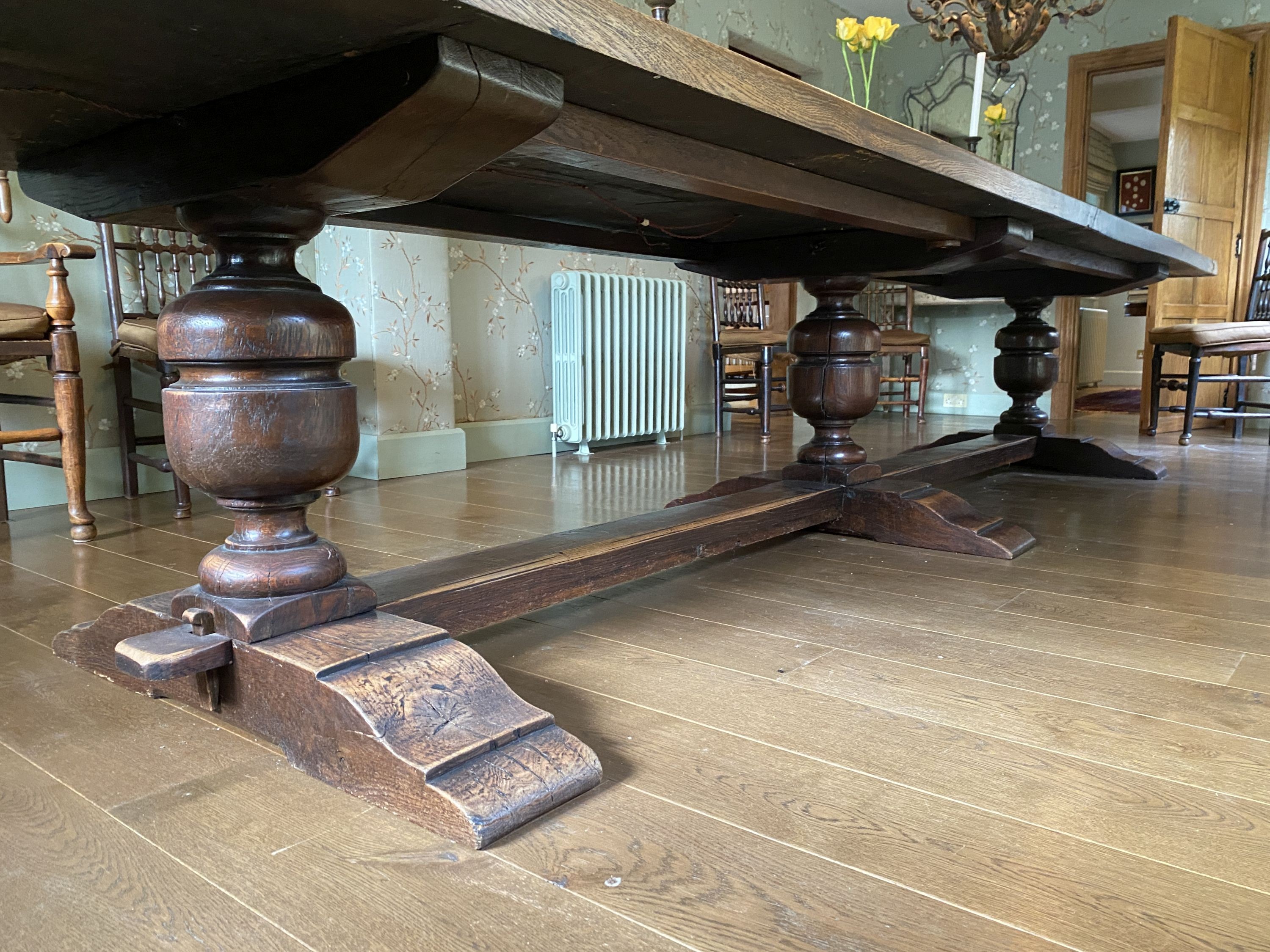 An impressively large 17th century style oak refectory table, with twin plank top on triple baluster supports and trestle foot, width 430cm depth 99cm height 74cm